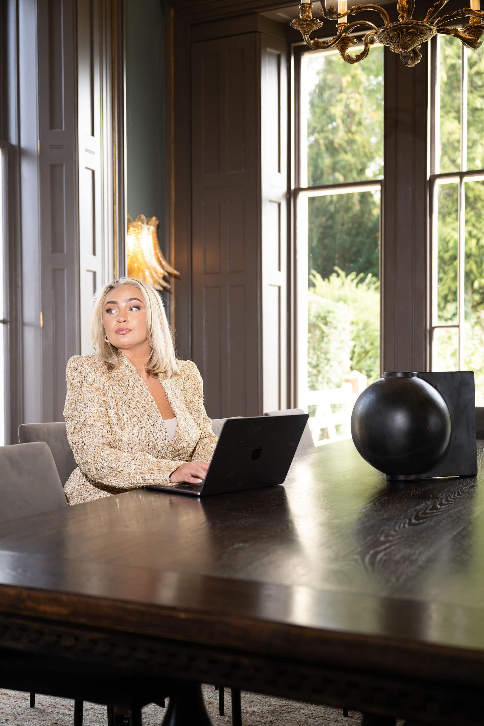 Emily Mallender, business coach, at a boardroom table with her laptop
