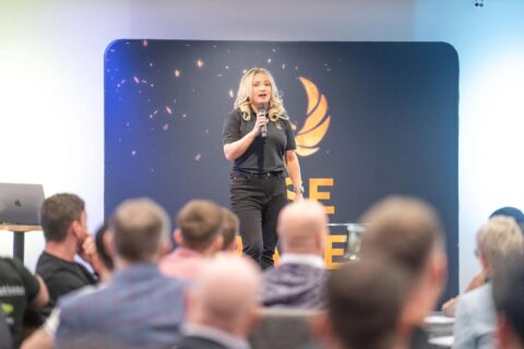 Emily Mallender speaking on stage to business owners