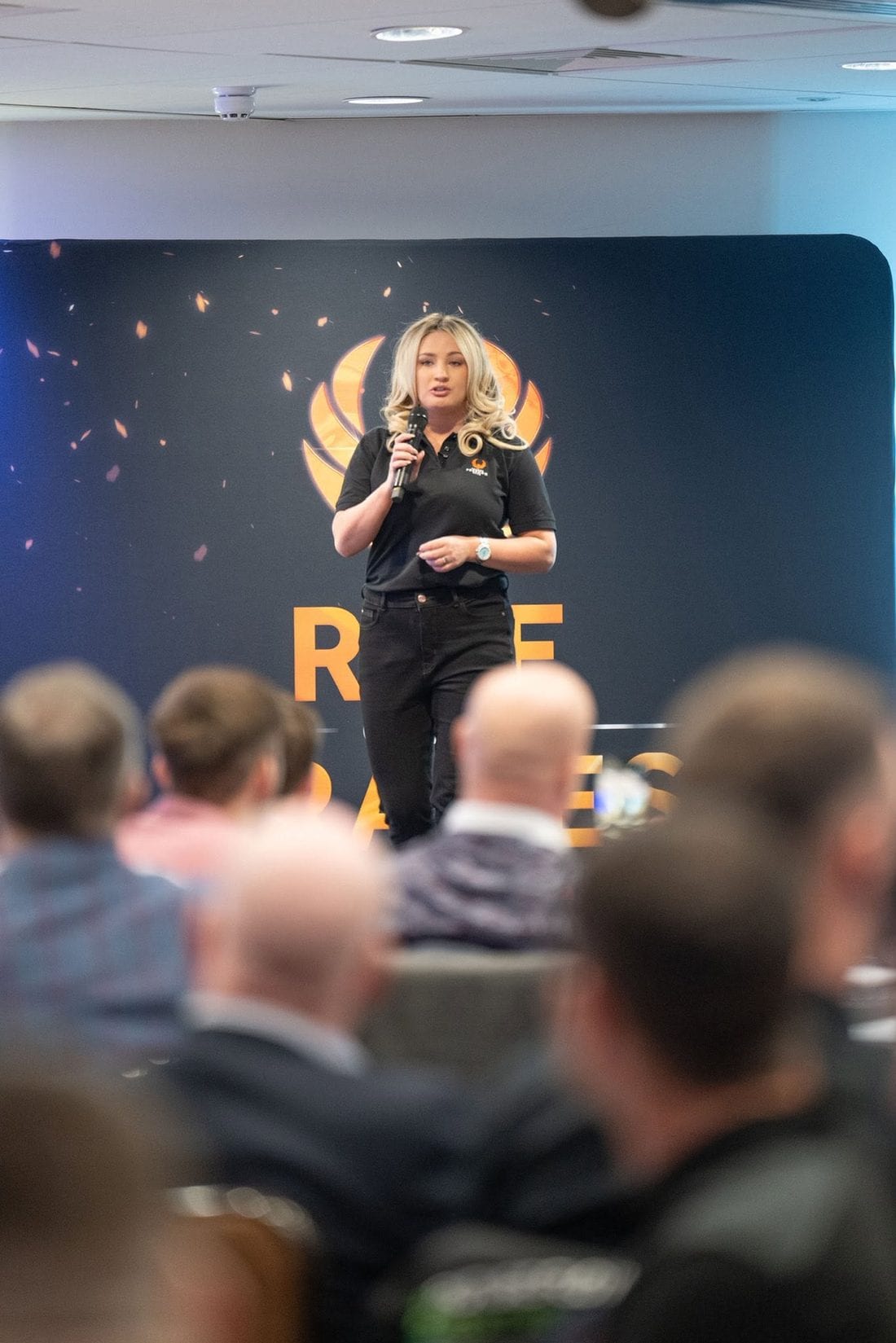 Emily Mallender speaking on stage to business owners at a Trades Freedom Club event