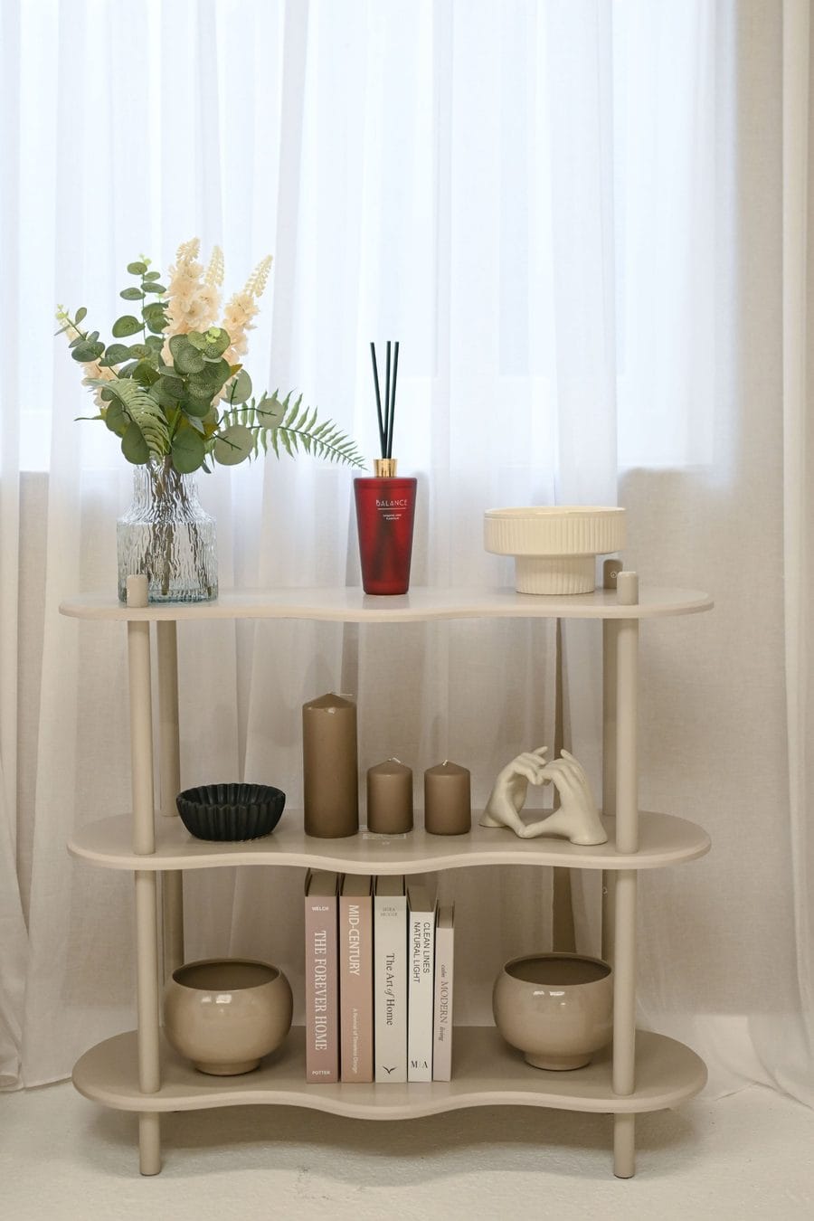Styled shelf set with candles, books and flowers at EMpowered Media Studios